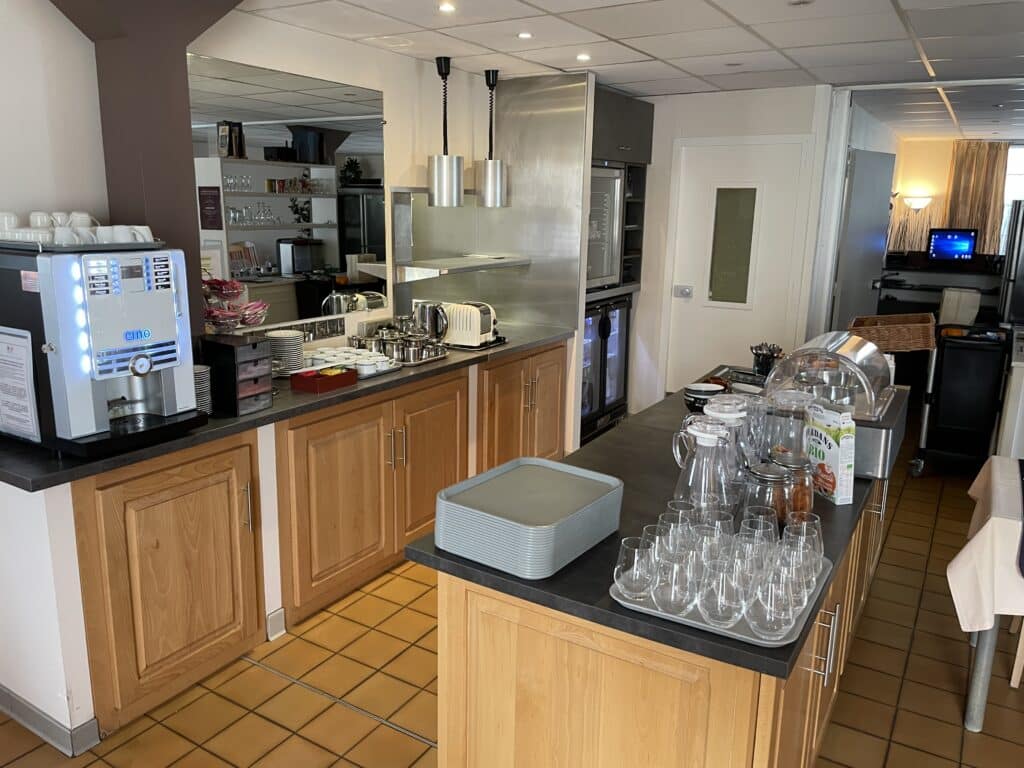 Buffet petit-déjeuner self-service avec machine à café CINO, grille-pain Dualit, plats, carafes, verres et céréales JORDANS BIO.