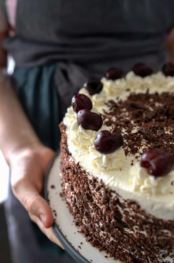 Close-up of a Black Forest cake topped with cherries and whipped cream.