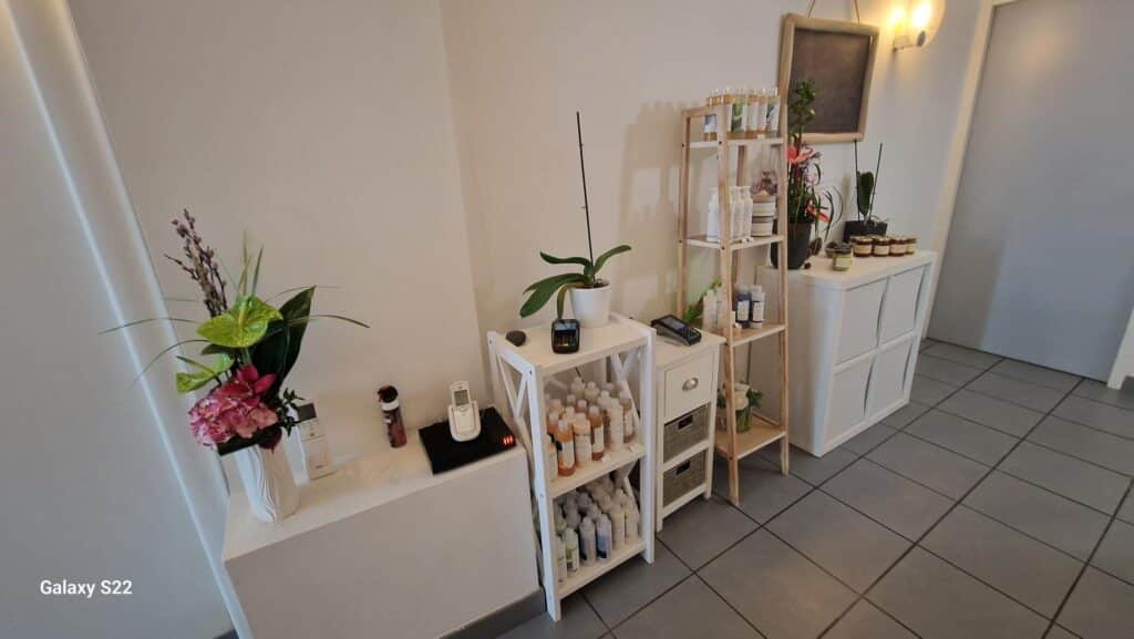 Intérieur de boutique avec produits de beauté sur étagères bois et blanches, fleurs, terminal de paiement. Photo Galaxy S22.