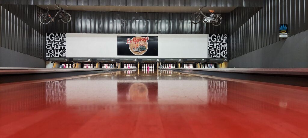 Piste de bowling Le Garage avec quilles et vélos vintage suspendus. Ambiance rétro industrielle sur huit pistes.