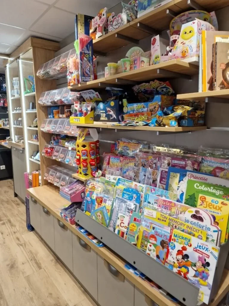 Rayonnage coloré d'un magasin avec magazines Mickey Junior, jeux, coloriages et confiseries PEZ pour enfants.